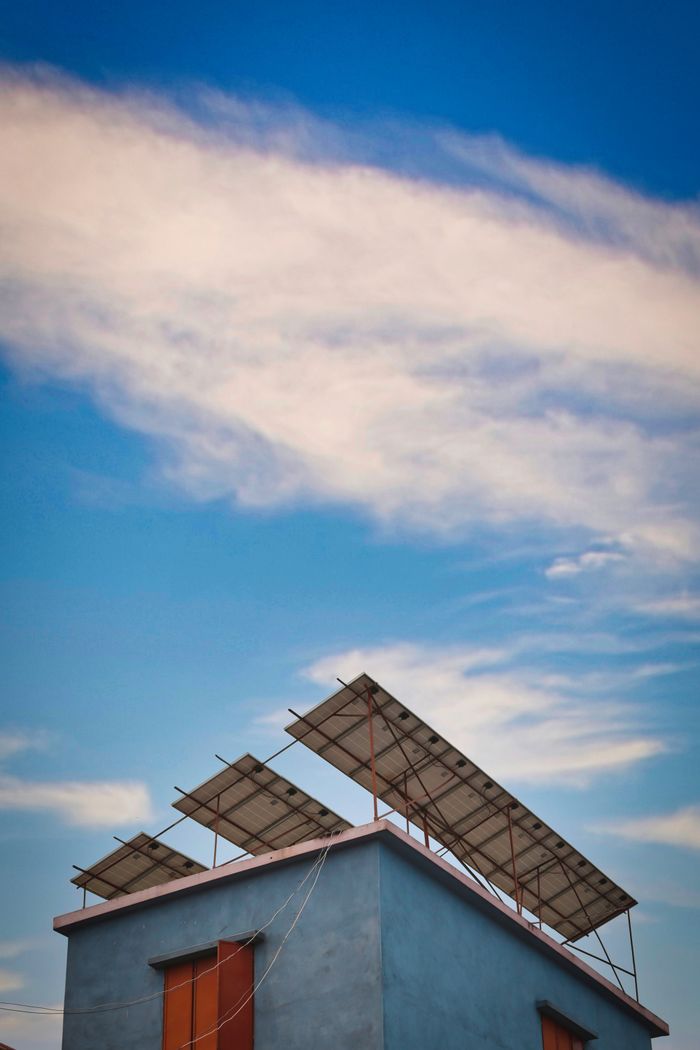 service-04 Solar panels mounted on a rooftop against a clear blue sky.